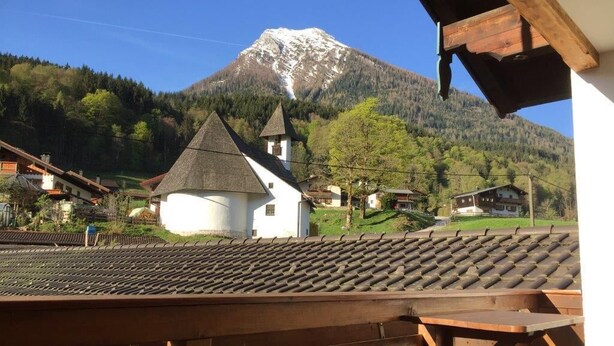 A mountain view with a church and residential buildings.
