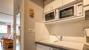 A compact kitchen with a sink, two wall-mounted microwaves, and a refrigerator. - South-Facing Studio Near Aquatic Area, Pets Allowed (La Clusaz)