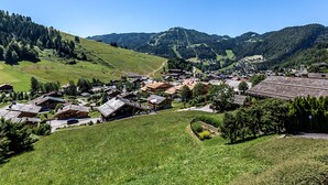 A village with traditional houses, a central square, and surrounding hills.