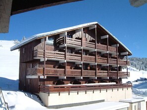 A multi-story wooden chalet with balconies, situated on a snowy mountain. - Les Saisies - Studio Cabin 4 People, South (Les Saisies)