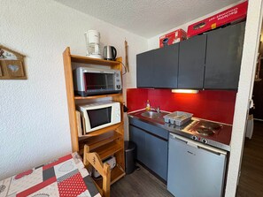 Eine kleine Küche mit einer Mikrowelle, einem Toaster und einem Spülbecken.