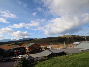 A mountain town with buildings, a road, and a view of the mountains.