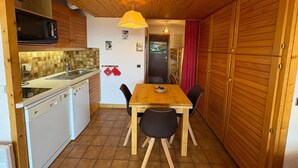 A compact kitchen with a microwave, sink, and wooden cabinets. - 1-star studio-cabin at Les Saisies, 4 people, south balcony (Les Saisies)