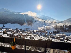 Une ville de montagne enneigée, avec des bâtiments et une piste de ski.
