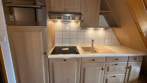 A compact kitchen with a stove, sink, and cabinets. - Les Saisies - Spacious 3 Rooms Mezzanine 2 Bathrooms for 8 Pers. (Les Saisies)