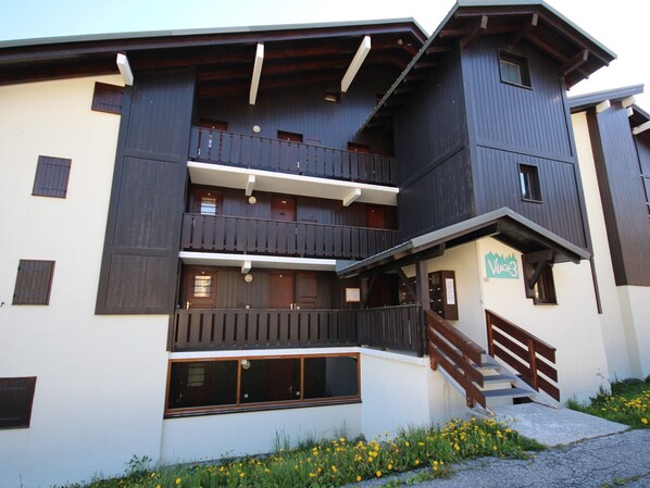 A multi-story building with balconies, a staircase, and a sign that reads "Village3".