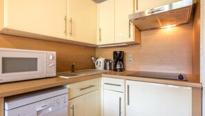 A compact kitchenette with a microwave, coffee maker, and dishwasher. - Studio for 4 people with garage, near village and lifts (La Clusaz)