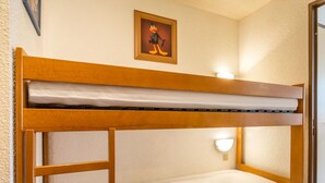 A bunk bed with a ladder, a framed picture on the wall, and a wall-mounted light fixture. - Studio for 4 people with garage, near village and lifts (La Clusaz)