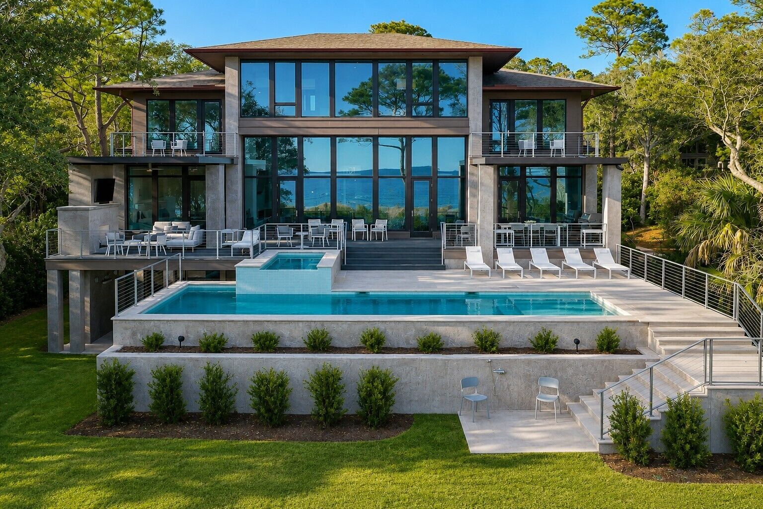 Une maison moderne à deux étages, dotée d’une piscine, d’un espace extérieur aménagé et offrant une vue sur le paysage environnant.