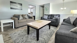 A modern living room with two sofas, a coffee table, and a small white table. - RIVERVIEW VILLA AT OCEAN BEACH: 5 QUEEN BEDS (New London)