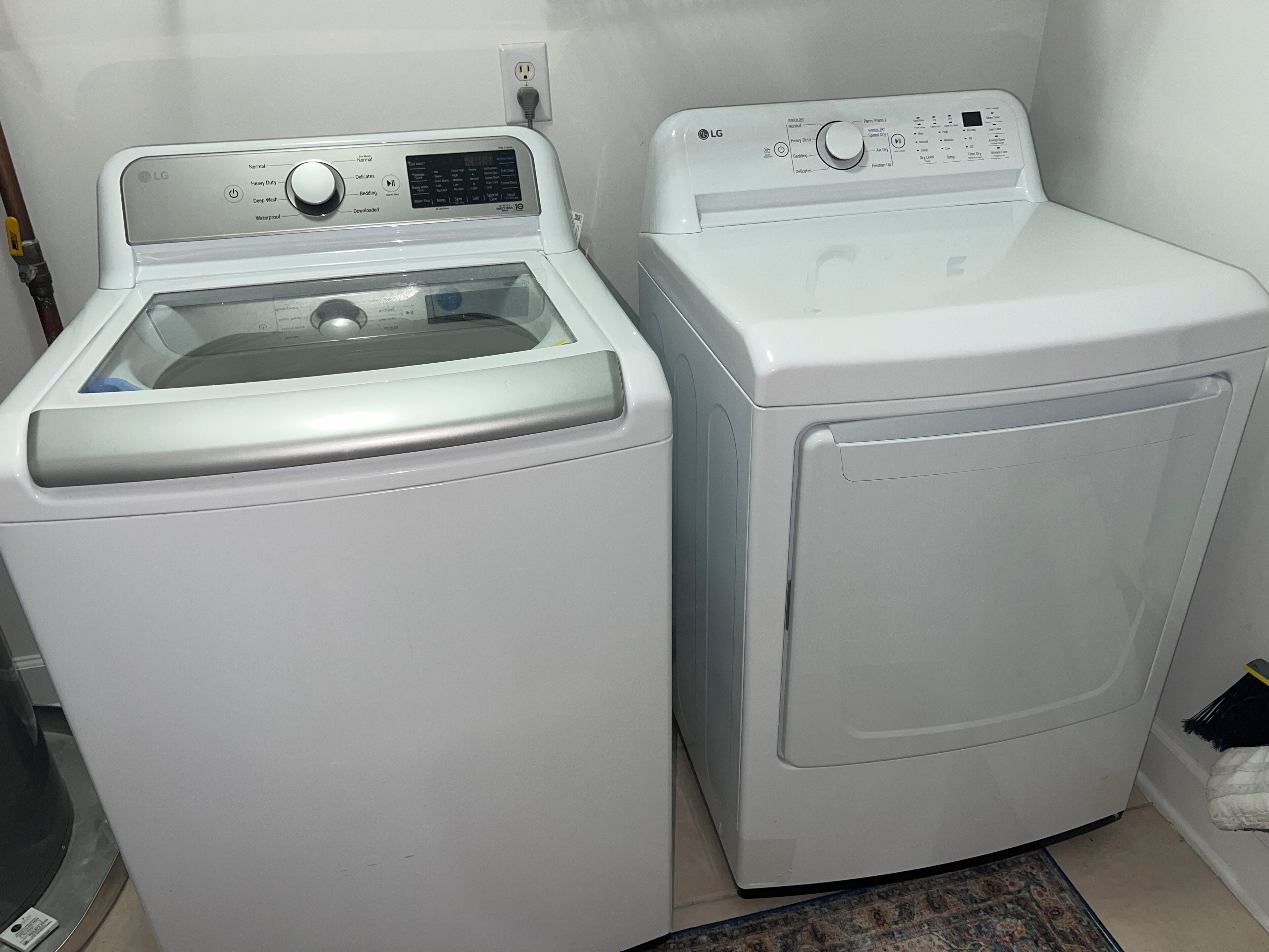 Two white front-loading washing machines side by side in a laundry room.