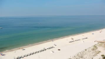 Guests can enjoy a serene beach experience with clear waters and comfortable seating.