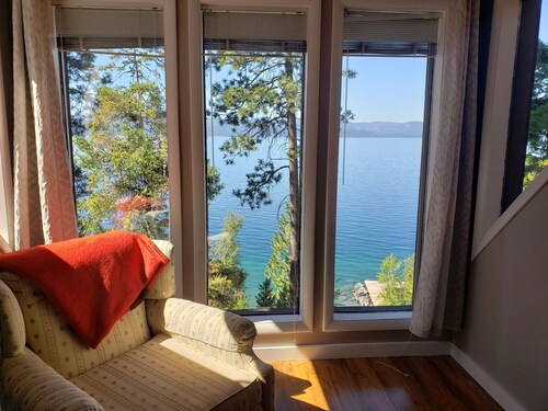 Peaceful home enveloped in a quiet, scenic landscape adjacent to a rocky beach.