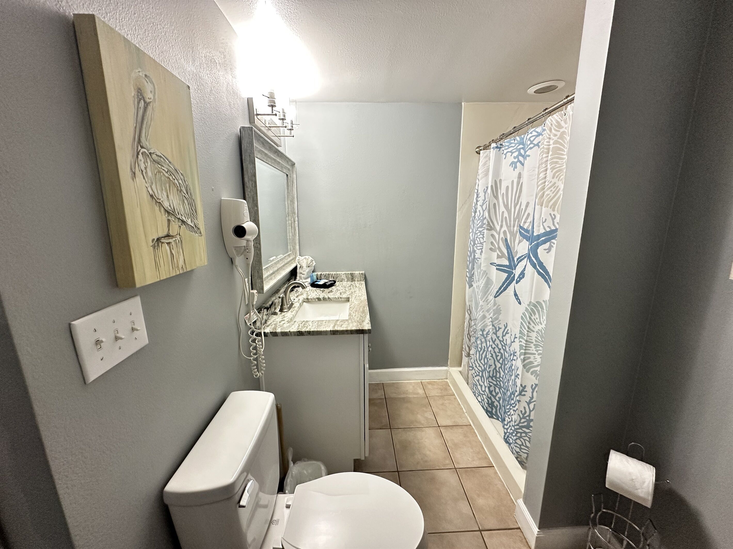 A bathroom with a toilet, sink, and shower.