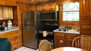 A wooden cabin kitchen with a refrigerator, microwave, stove, and sink. - *Winter Special* 2 bed 2 bath 10 min PF Private (Sevier County)