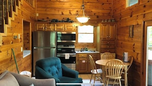 A cozy cabin interior with a dining area, kitchen, and a large window. - *Winter Special* 2 bed 2 bath 10 min PF Private (Sevier County)