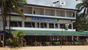 A two-story building with a sign reading "HOTEL RITAS & BEACH RESTAURANT". - Hotel Ritas & Beach Restaurant (Hikkaduwa)