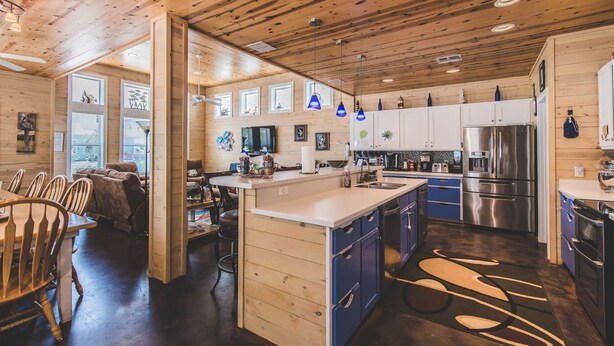 Une cuisine moderne avec des meubles en bois, des appareils en acier inoxydable et un îlot central.
