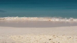 A beach with clear turquoise water and white sand. - Beautiful Hibiscus House (Governor's Harbour)