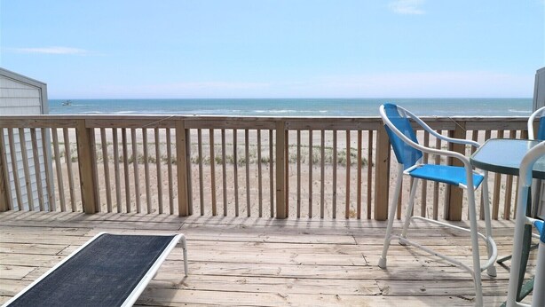 A wooden deck with a view of the beach and ocean. - Oceanfront 2-bedroom Queen's Grant Condo (Topsail Beach)