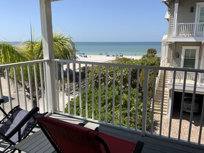 En balkon med udsigt over en strand og hav.