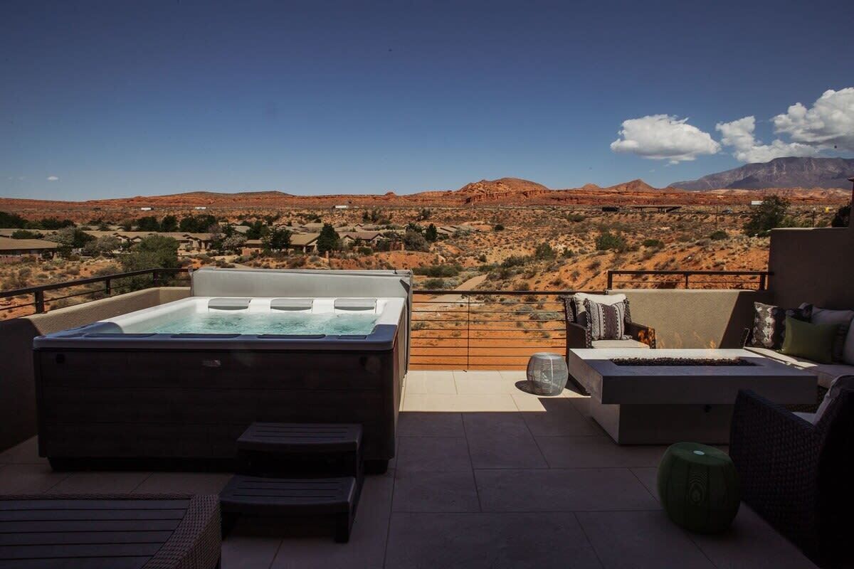 A hot tub on a terrace with a view of a desert landscape.