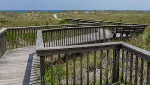 A wooden boardwalk leading to a beach with a clear sky. - Serenity Now | Community Beach Access + Pool! (Topsail Beach)