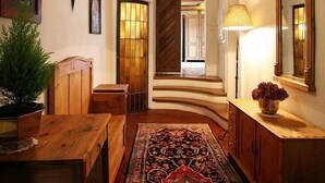 A hallway with a wooden bench, a rug, a lamp, and a mirror. - Doppler's Apartment fully A/C (Prague)