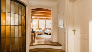 A staircase leading to a bedroom with a wooden ceiling and a bed with a checkered bedspread. - Doppler's Apartment fully A/C (Prague)