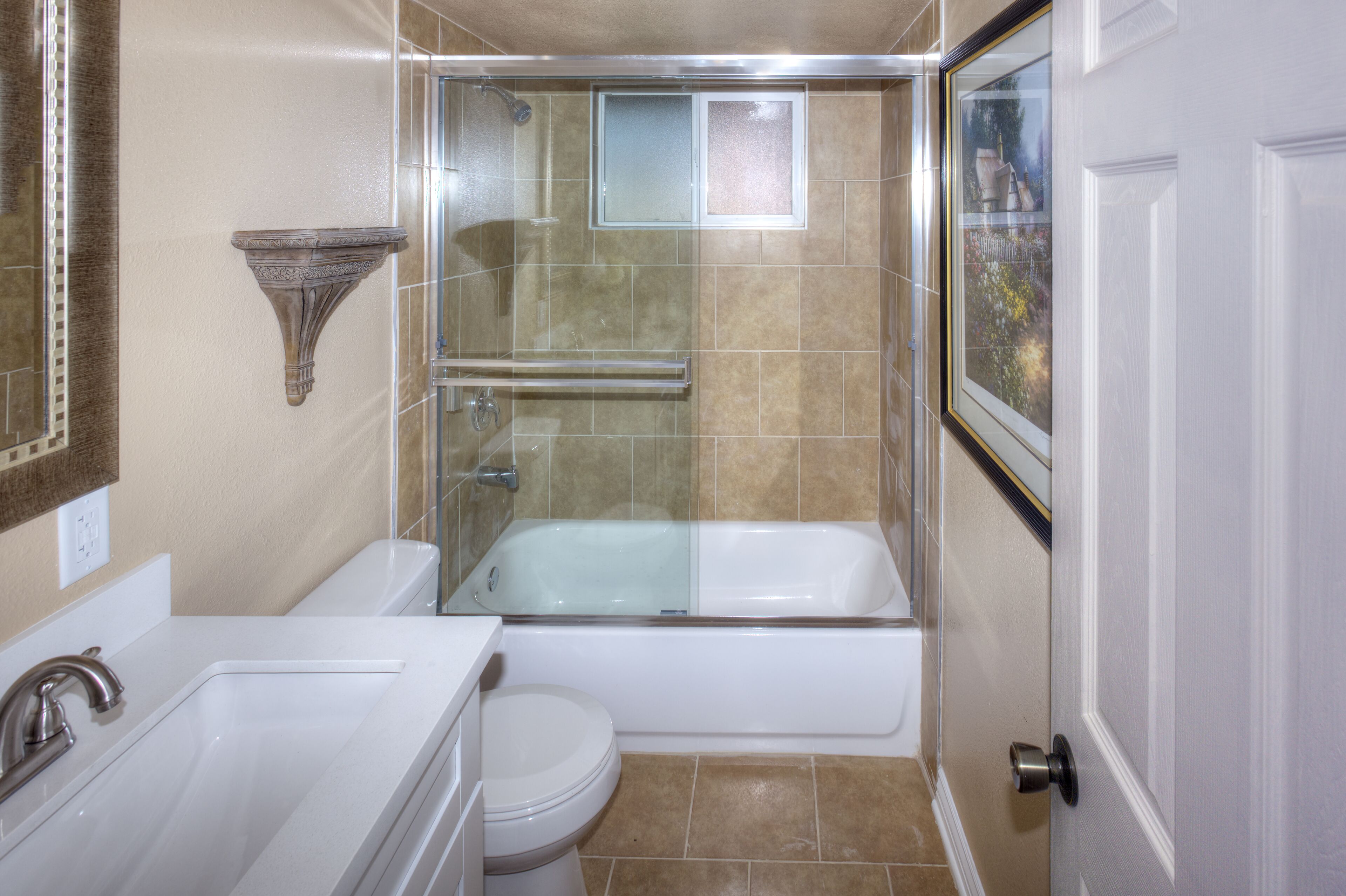 A bathroom with a bathtub, toilet, and sink.