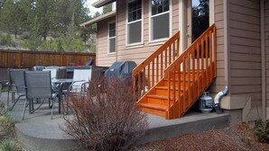 A house with a covered patio, outdoor furniture, and a wooden staircase leading to the front door. - Skyline Lodge, Gorgeous Setting, Walk to Downtown! (Bend)