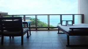 Varanda com vista para o oceano, uma mesa e duas cadeiras.