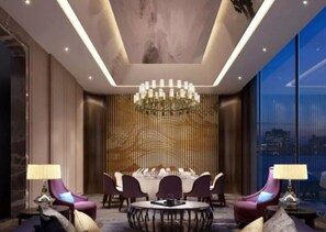 A modern dining area with a chandelier, round table, and purple chairs. - Wanda Realm Qiqihar (Qiqihar)