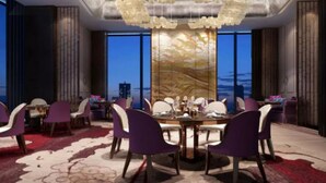 A modern dining area with a high ceiling, large windows, and purple chairs. - Wanda Realm Qiqihar (Qiqihar)