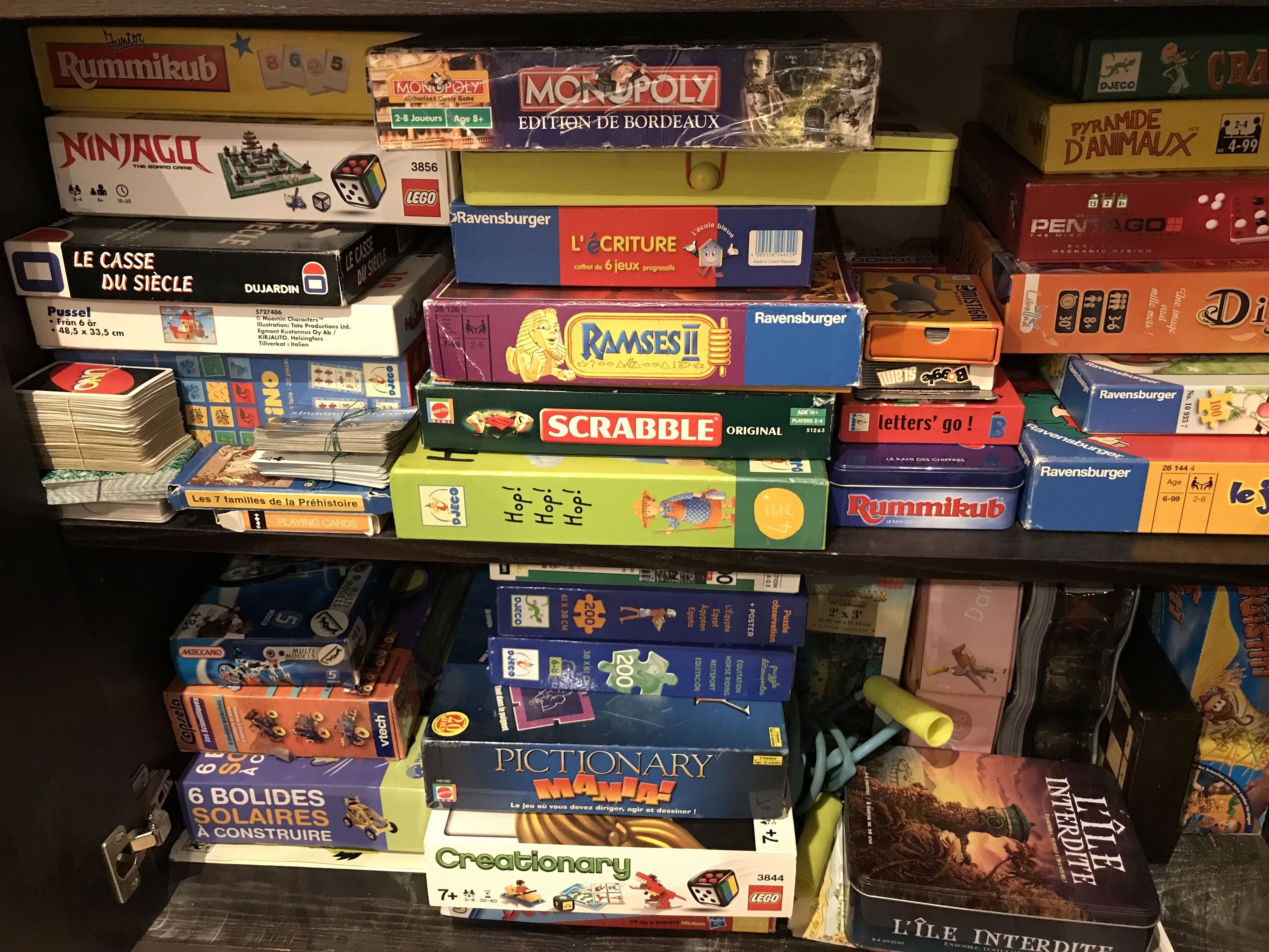 Uma estante repleta de jogos de tabuleiro e quebra-cabeças.