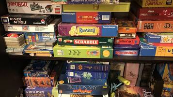 Uma estante repleta de jogos de tabuleiro e quebra-cabeças.