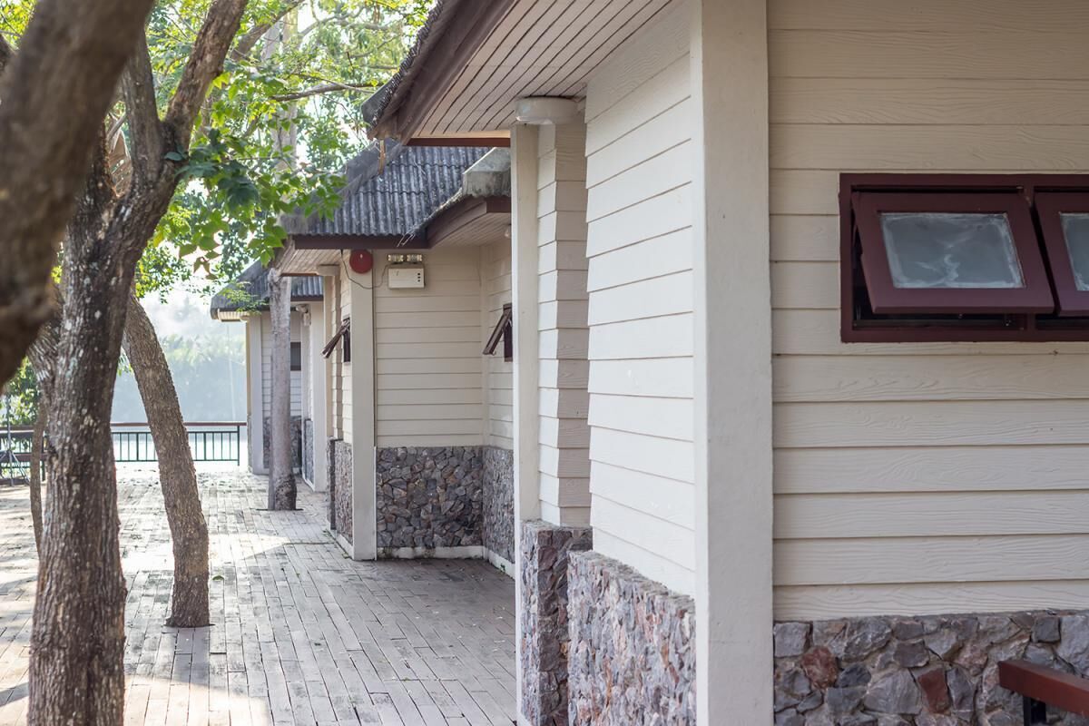 A building with a covered porch, stone accents, and a wooden deck.