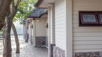 A building with a covered porch, stone accents, and a wooden deck.