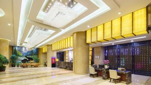 A spacious lobby with a grand piano, a reception desk, and a large mural on the wall. - Oasis Grand Hotel (Ür ümqi)