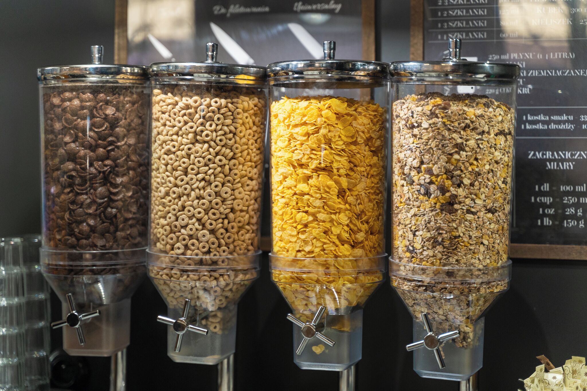 Four dispensers with different types of cereal and grains.