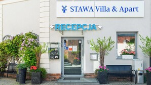 A reception area with a sign for 'STAWA Villa & Apart' and a bench outside. - Stawa Villa & Apart (Swinoujscie)