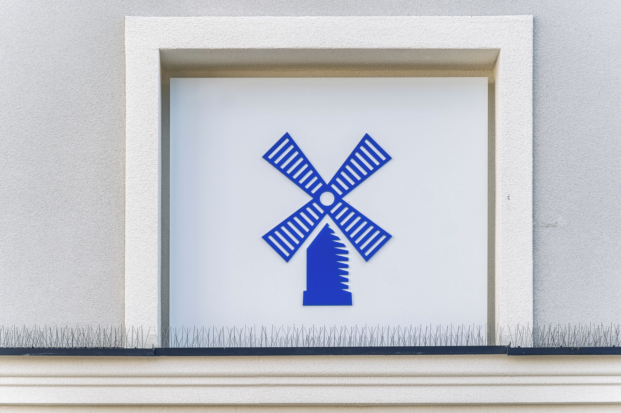 A framed windmill symbol on a wall.