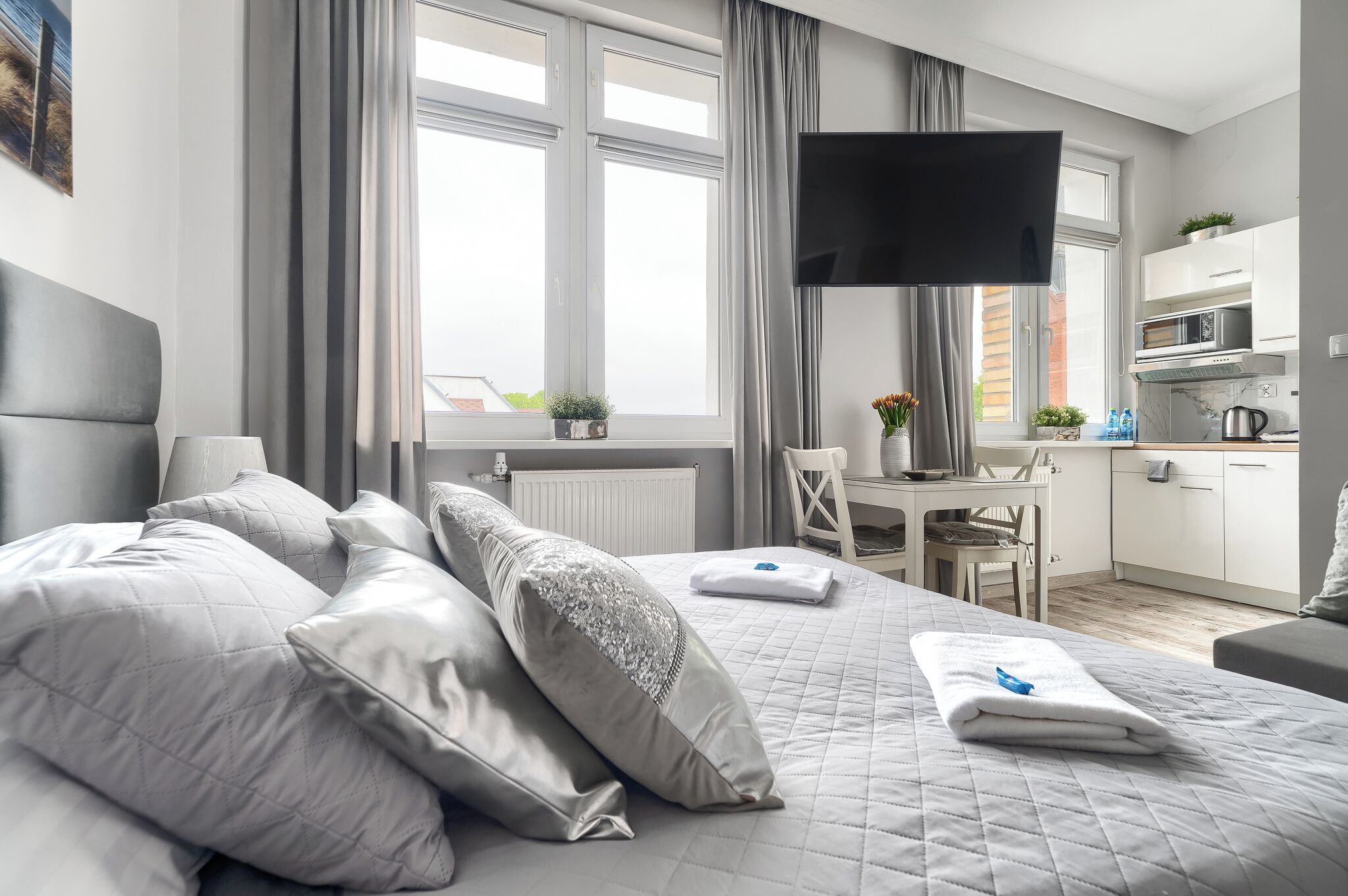 Ein modernes Hotelzimmer mit einem großen Bett, einem Schreibtisch und einer Küchenzeile.