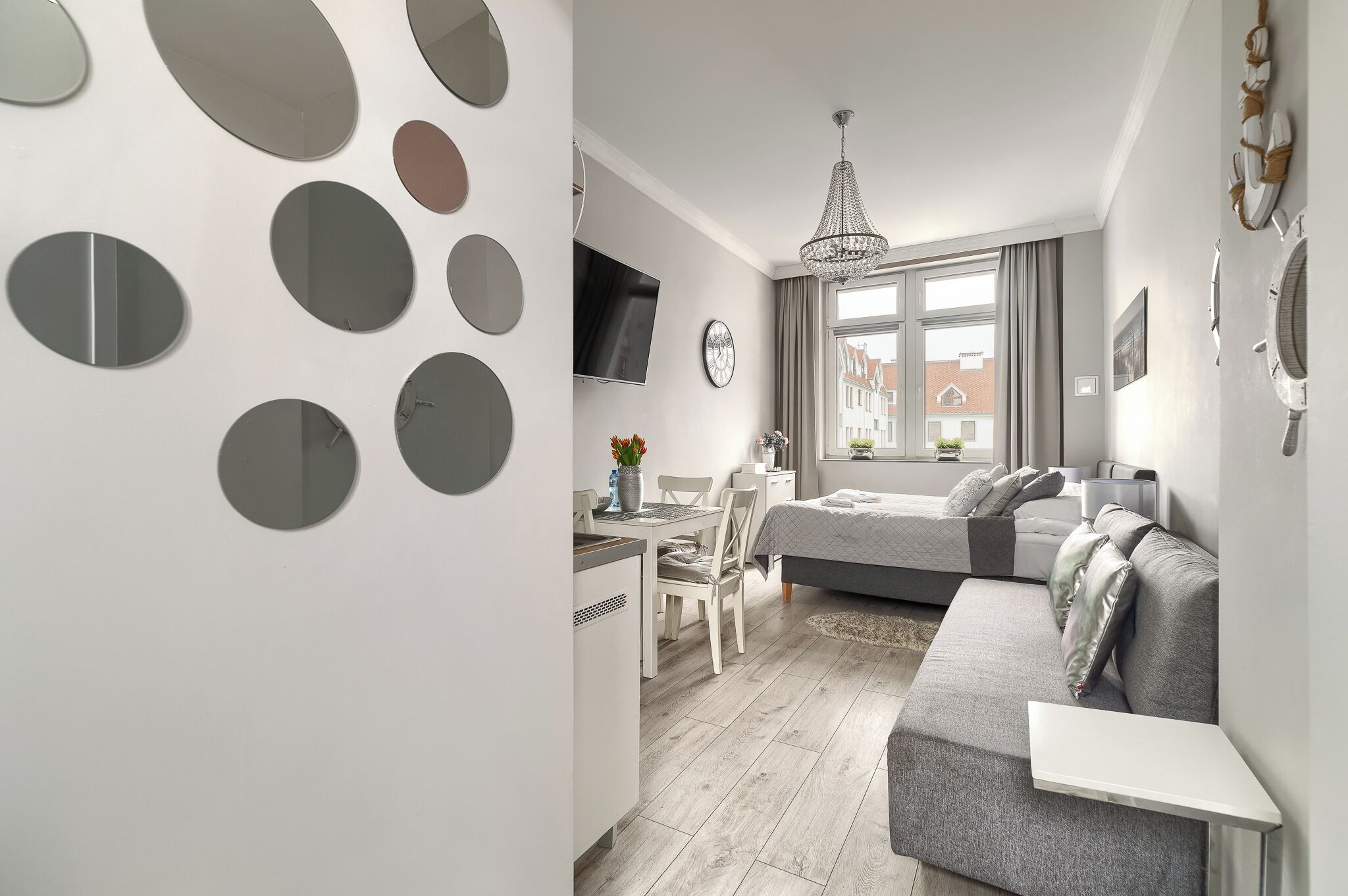 Ein modernes Schlafzimmer mit Bett, Nachttisch und einem an der Wand befestigten Fernseher.