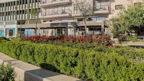 Un edificio moderno con diversi piani, balconi e un ristorante chiamato 'DANTE' al piano terra.