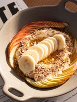 Eine Schüssel Haferflocken mit Bananenscheiben und Granola.