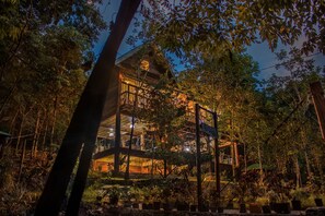 A multi-story building with a balcony, surrounded by dense foliage. - El Cielo Riverfront Villas (Pandan)