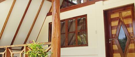 Una estructura de madera con techo inclinado, ventanas grandes y una puerta con diseño geométrico.