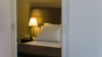 Une chambre d’hôtel avec un lit, une table de chevet, une lampe et un miroir.