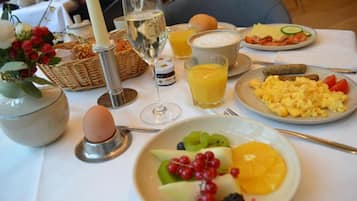 A breakfast setting with a plate of scrambled eggs, toast, and a bowl of soup.
